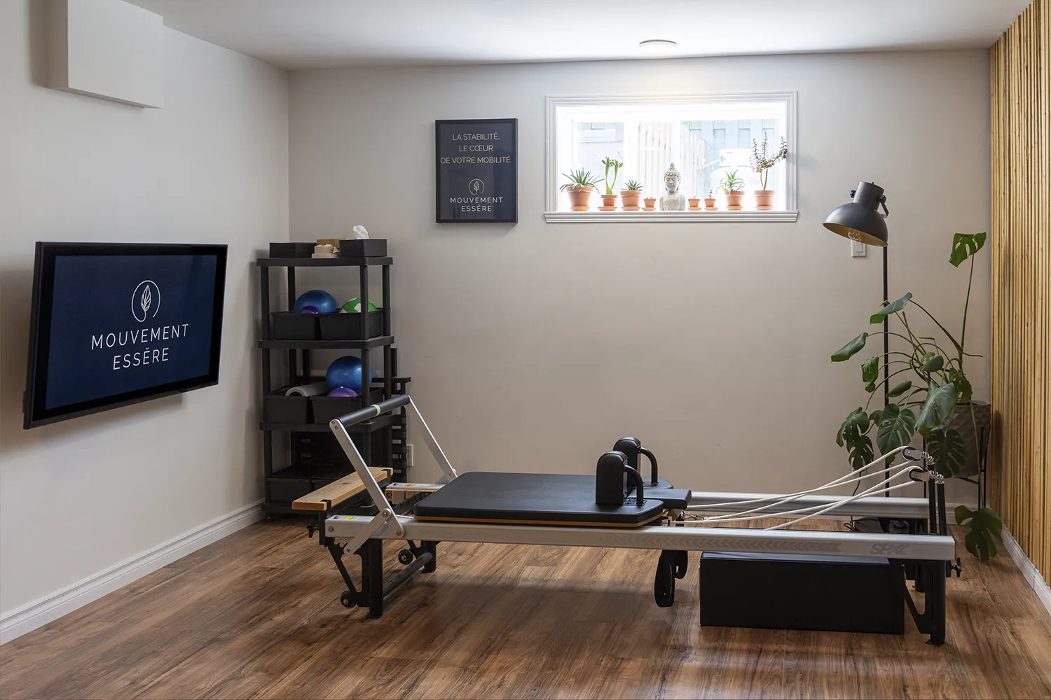 Studio de Pilates Mouvement Essĕre Blainville avec appareil Reformer SPX et écran de télévision.