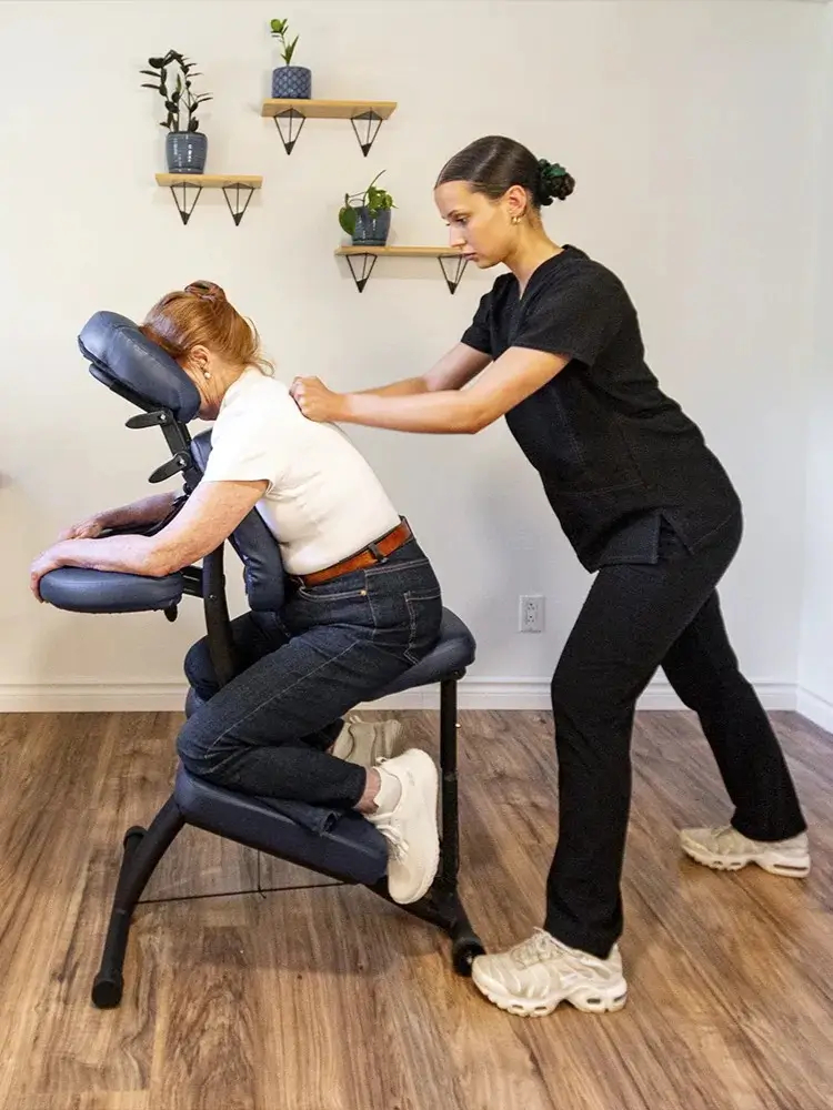 Julia Belzile, massothérapeute chez Mouvement Essĕre, effectuant un massage sur chaise ergonomique pour le bien-être en entreprise.