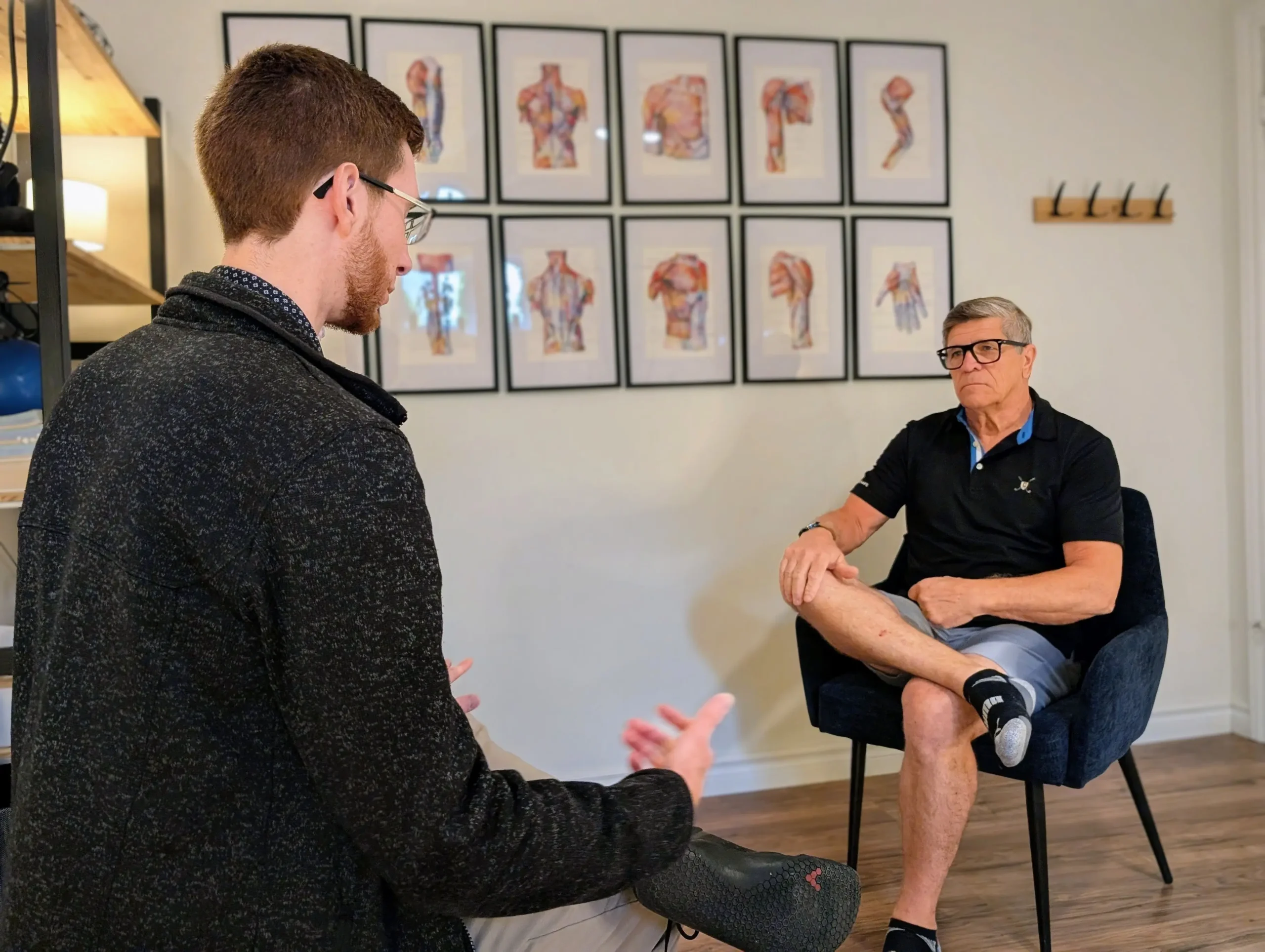 Joel Bérubé, Kinésiologue, de Mouvement Essĕre donne des conseils et explique des exercices à un patient en clinique.