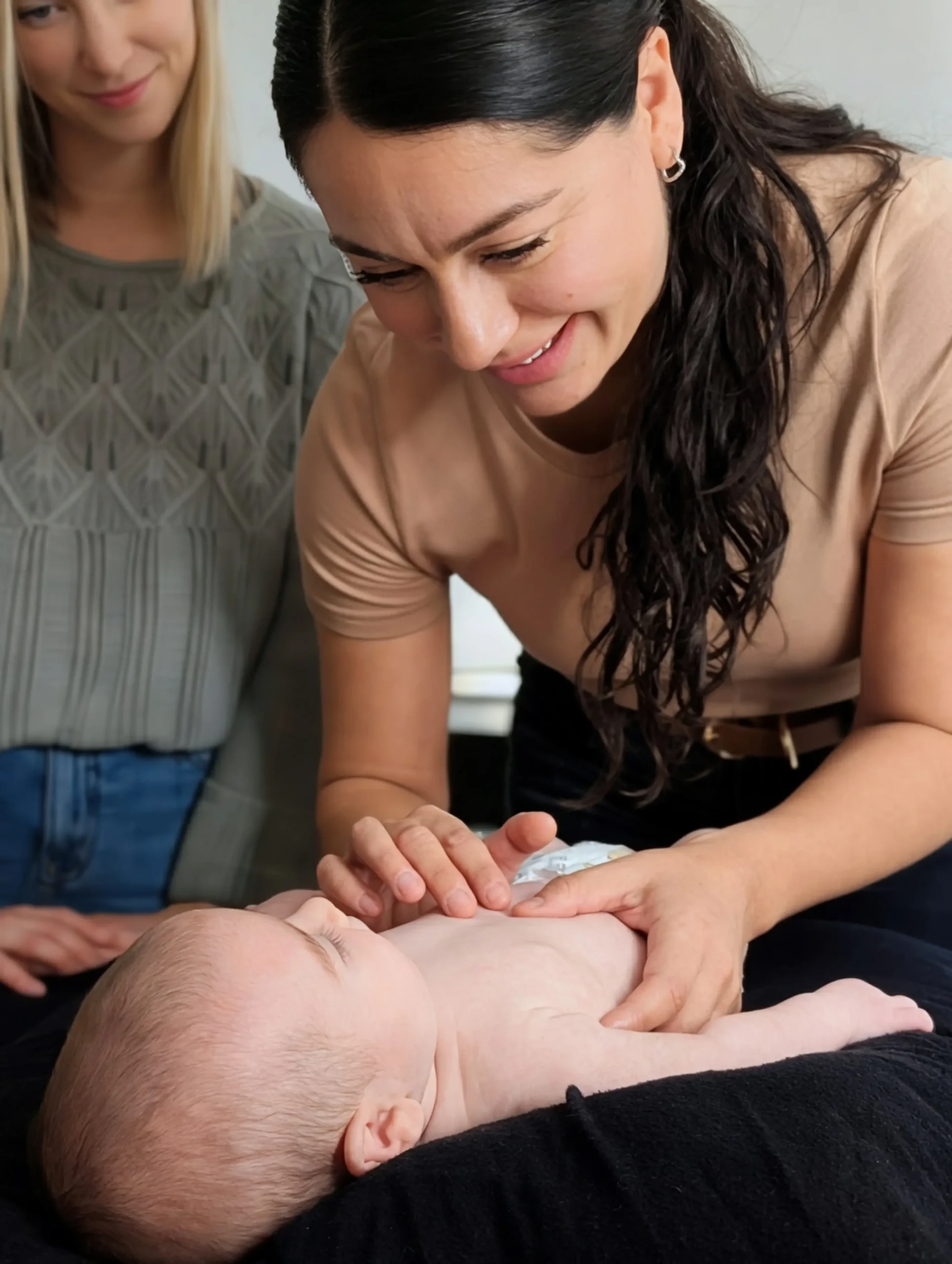 L'ostéopathe Ana Sierra tenant un nourrisson avec bienveillance lors d'une séance chez Mouvement Essĕre à Blainville.