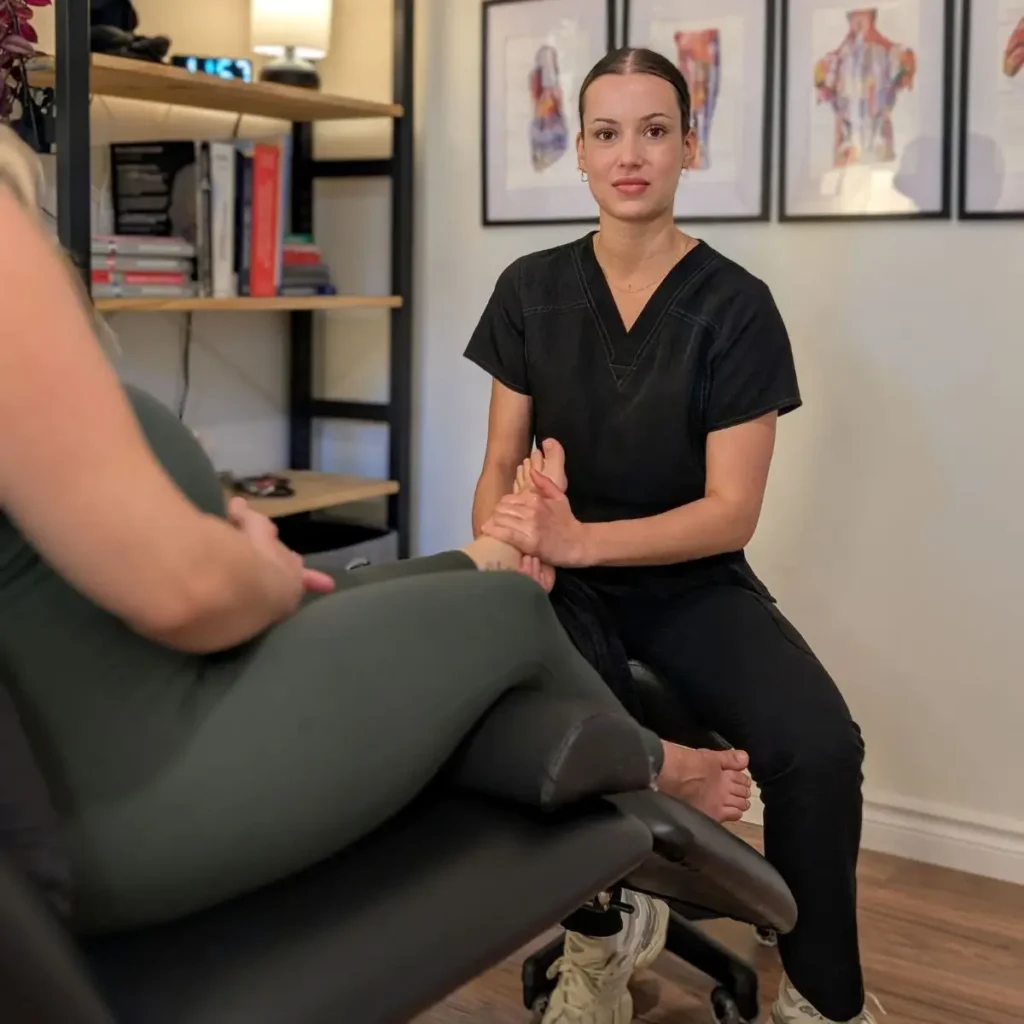 Julia Belzile, thérapeute chez Mouvement Essĕre à Blainville, effectuant une évaluation et un soin manuel précis.