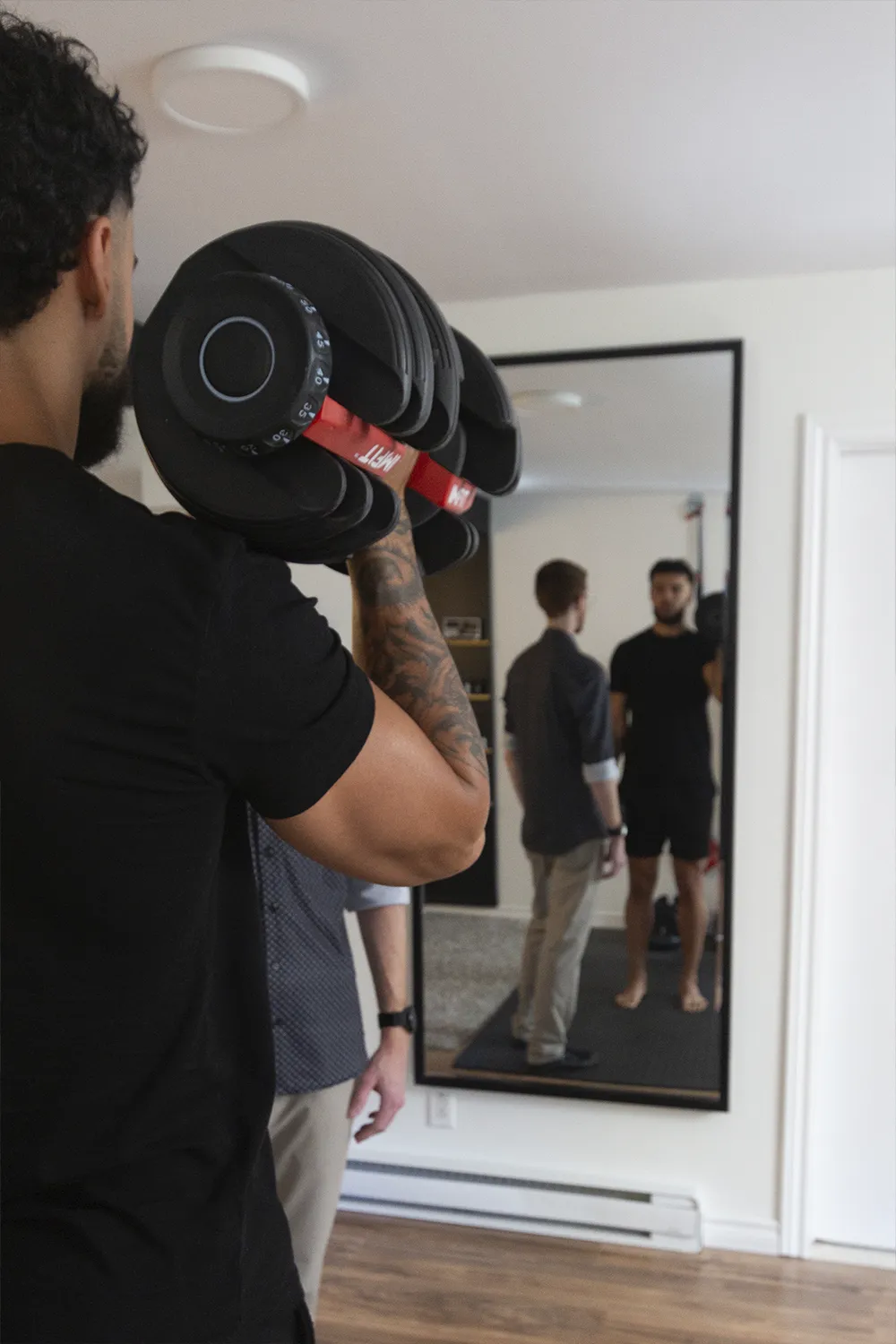 Client effectuant un exercice de force avec haltères sous supervision à la clinique Mouvement Essĕre de Blainville.